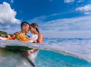 ウエディングドレスを着て海の中に立つ新郎新婦